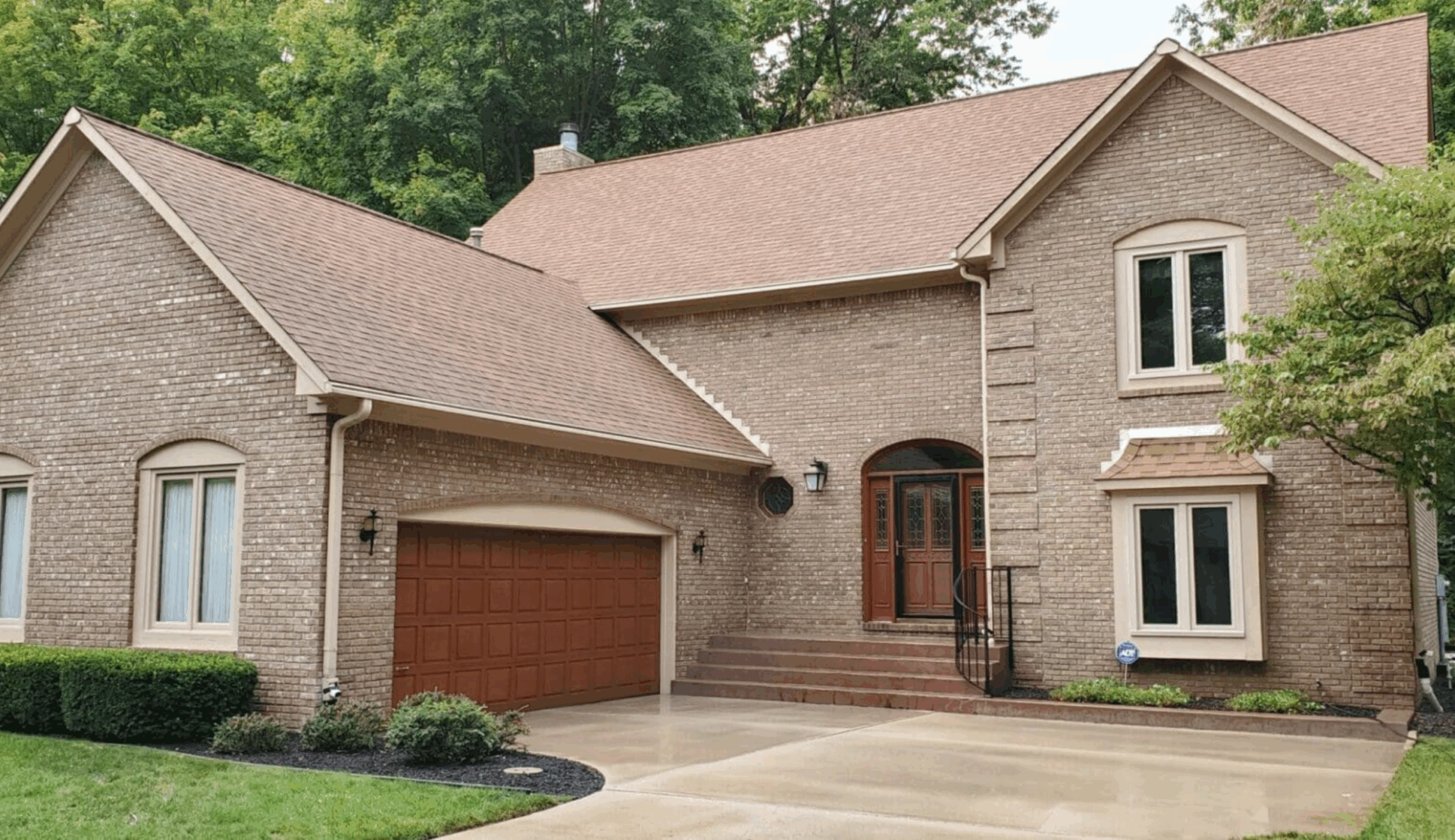 Brick house after annual exterior house washing, showing clean siding and driveway