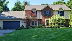 Professional exterior house cleaning with a soft wash system on vinyl siding in Indianapolis