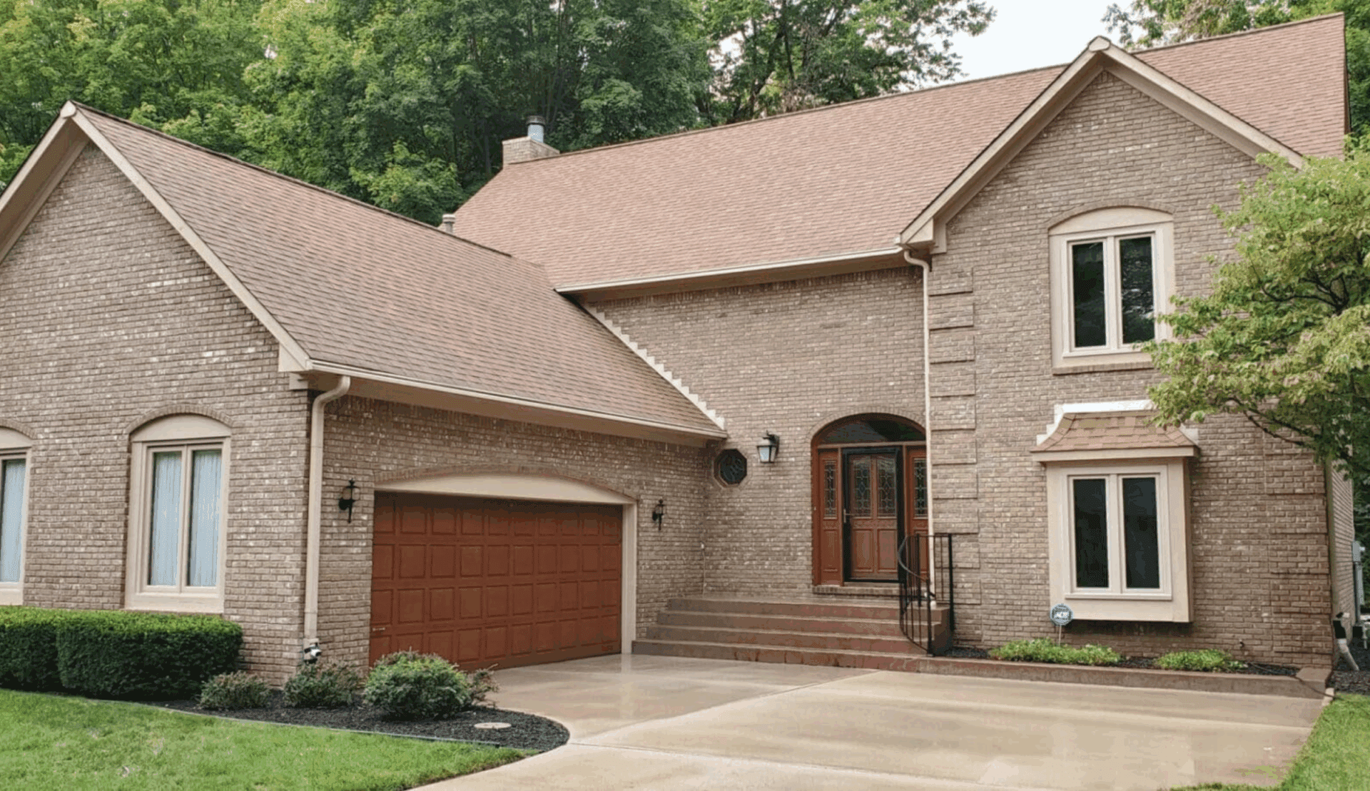 Brick house after annual exterior house washing, showing clean siding and driveway
